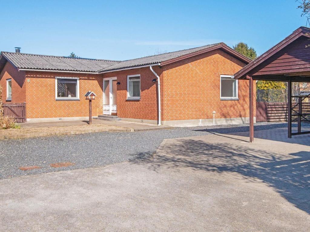 a red brick house with a basketball hoop in front of it at Holiday home Oksbøl LXIX in Oksbøl