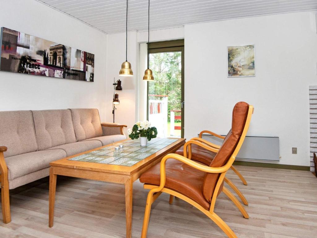 a living room with a couch and a table and chairs at Holiday home Glesborg XIX in Glesborg