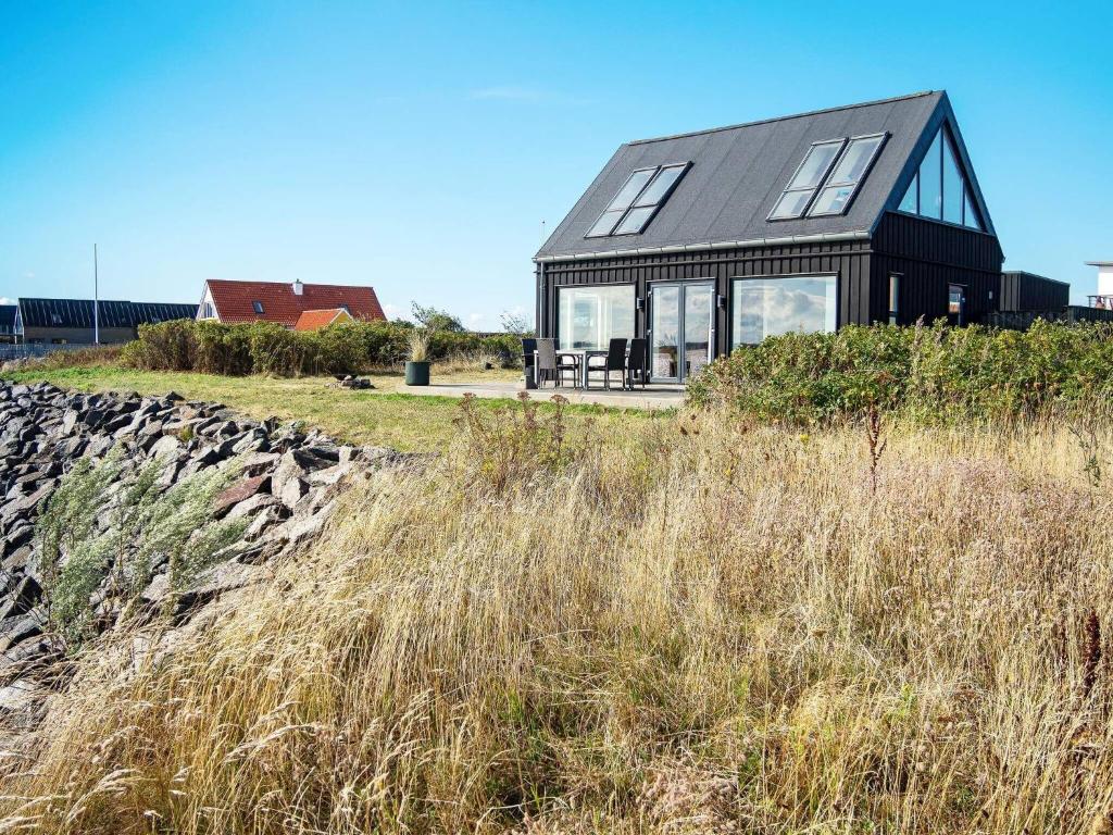 uma casa negra sentada no topo de uma colina em 5 person holiday home in Struer em Struer