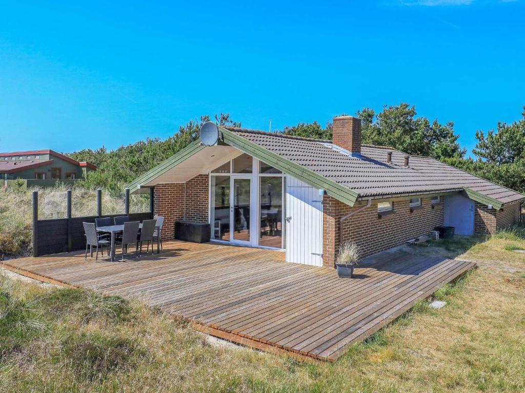 een huis met een terras met een tafel en stoelen bij Three-Bedroom Holiday home in Ringkøbing 1 in Ringkøbing