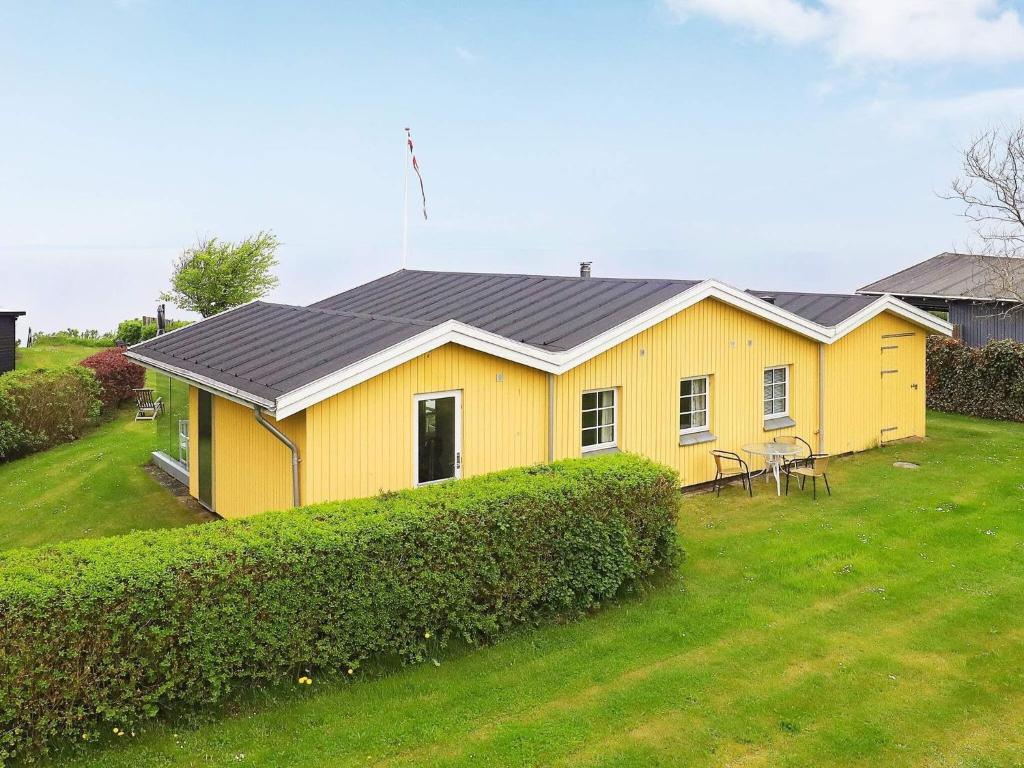 ein gelbes Haus mit schwarzem Dach auf einem Hof in der Unterkunft Holiday home Brenderup Fyn IX in Bro