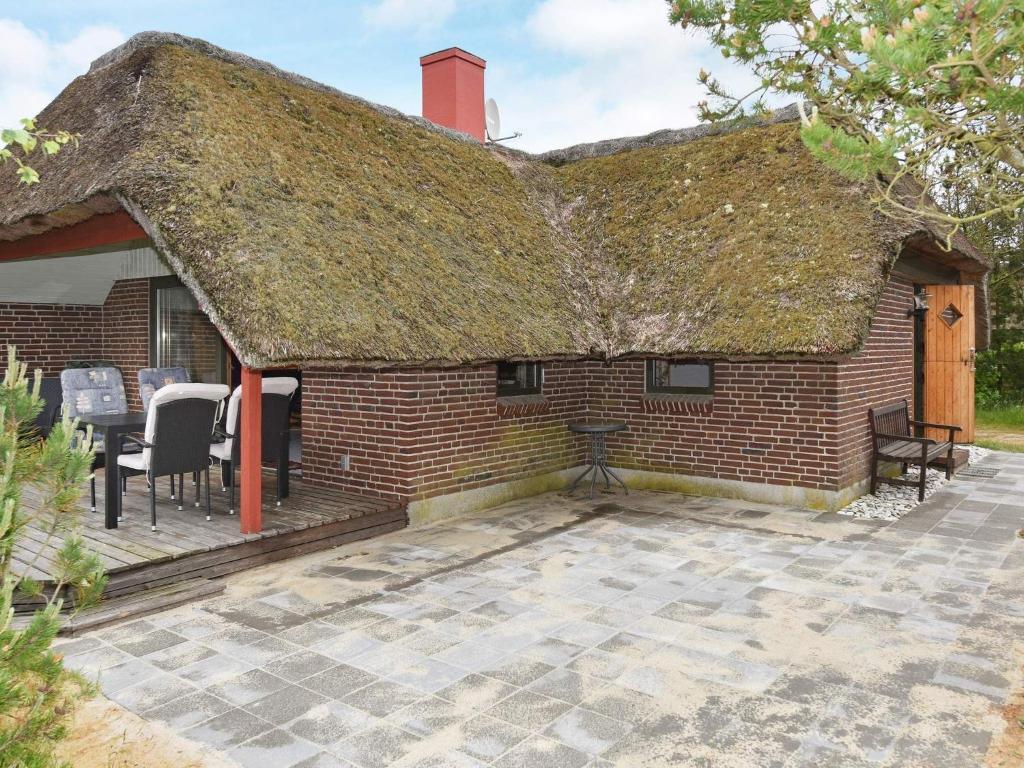 an old brick house with a thatched roof and a patio at 6 person holiday home in N rre Nebel in Nørre Nebel