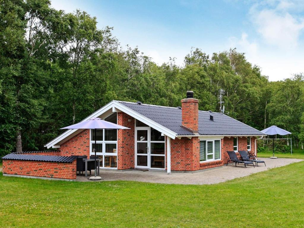una pequeña casa de ladrillo con patio y parrilla en 5 person holiday home in L s, en Læsø