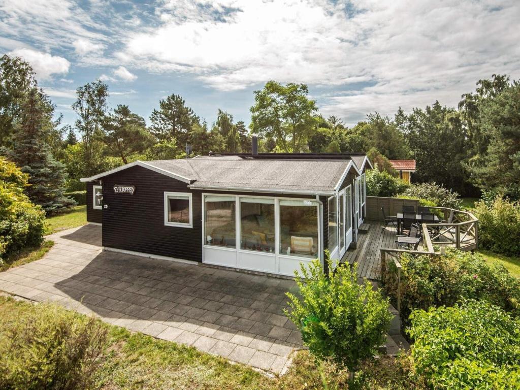 a black tiny house with a patio at 7 person holiday home in Knebel in Knebel