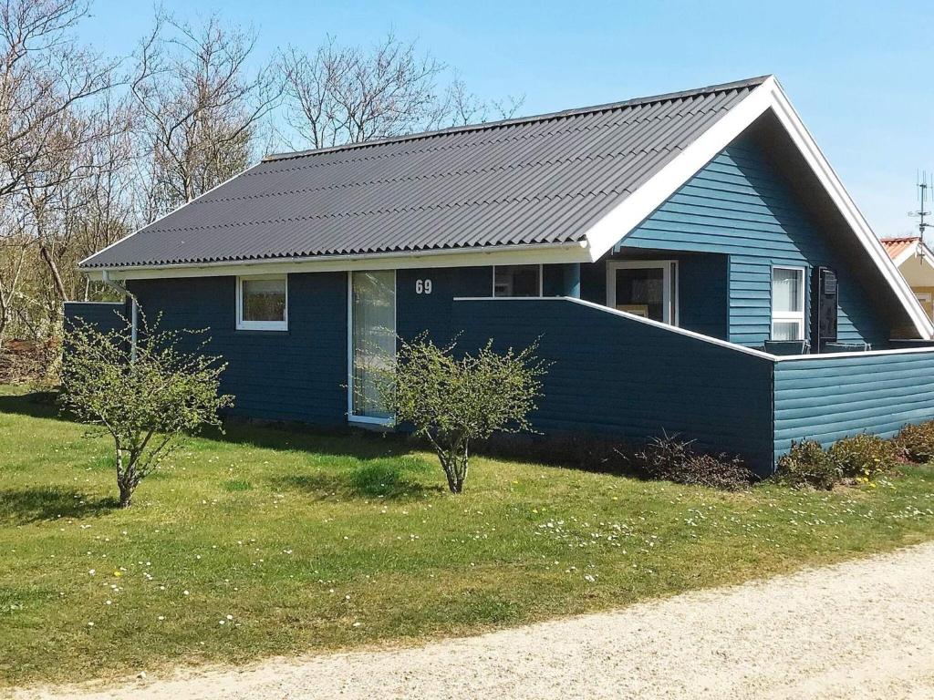 a blue house with a black roof on a yard at 4 person holiday home in Hemmet in Hemmet
