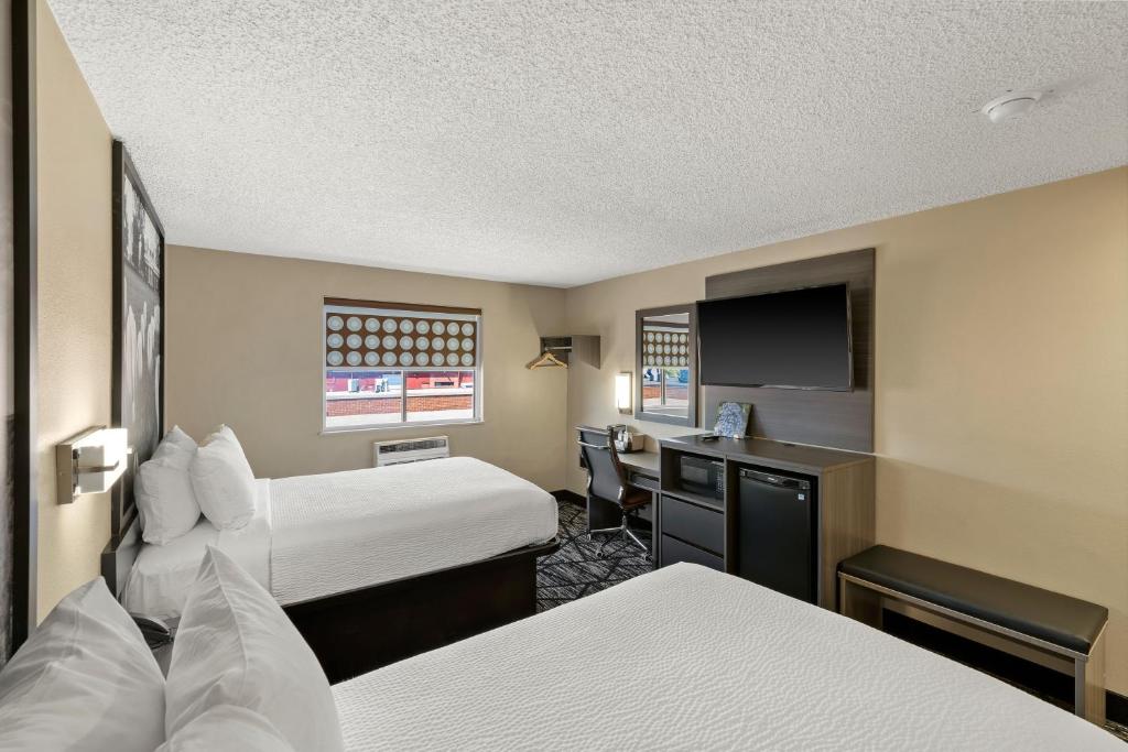 a hotel room with two beds and a desk at Super 8 by Wyndham Charlottesville in Charlottesville