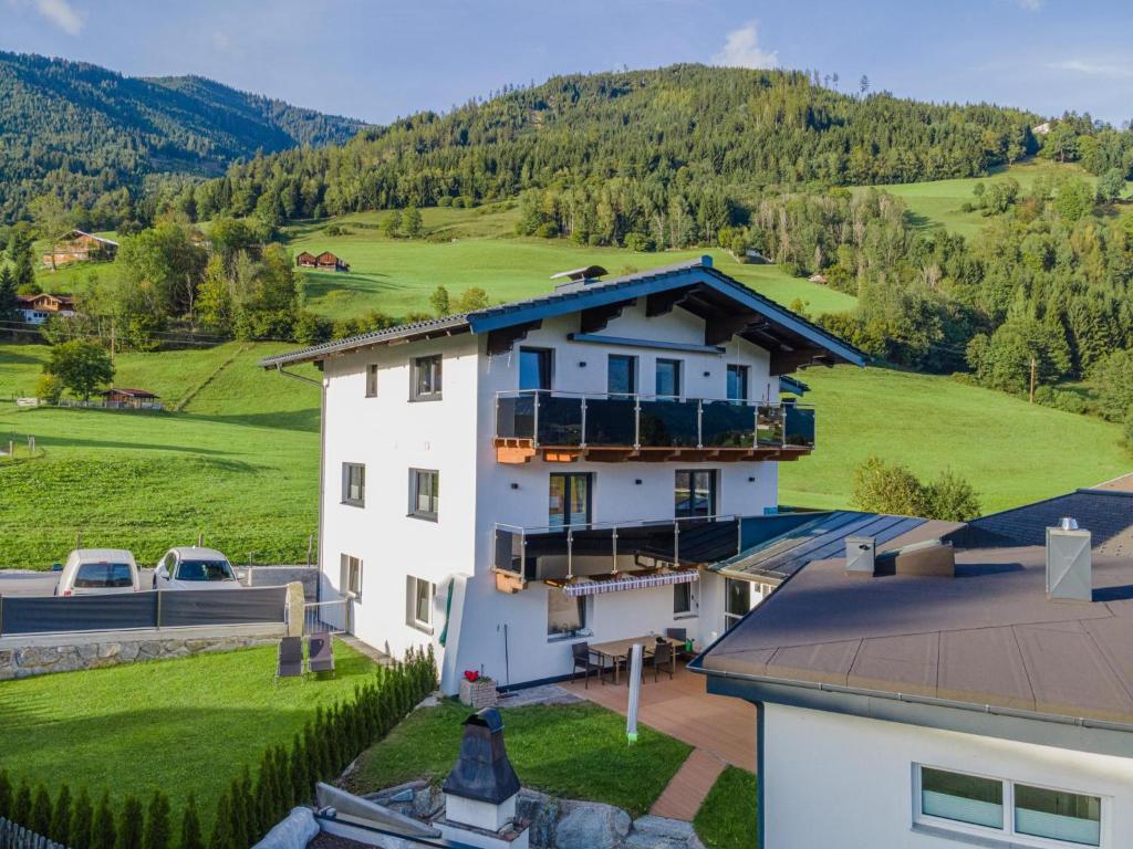 a white house with a mountain in the background at Apartment Daisy in Stuhlfelden