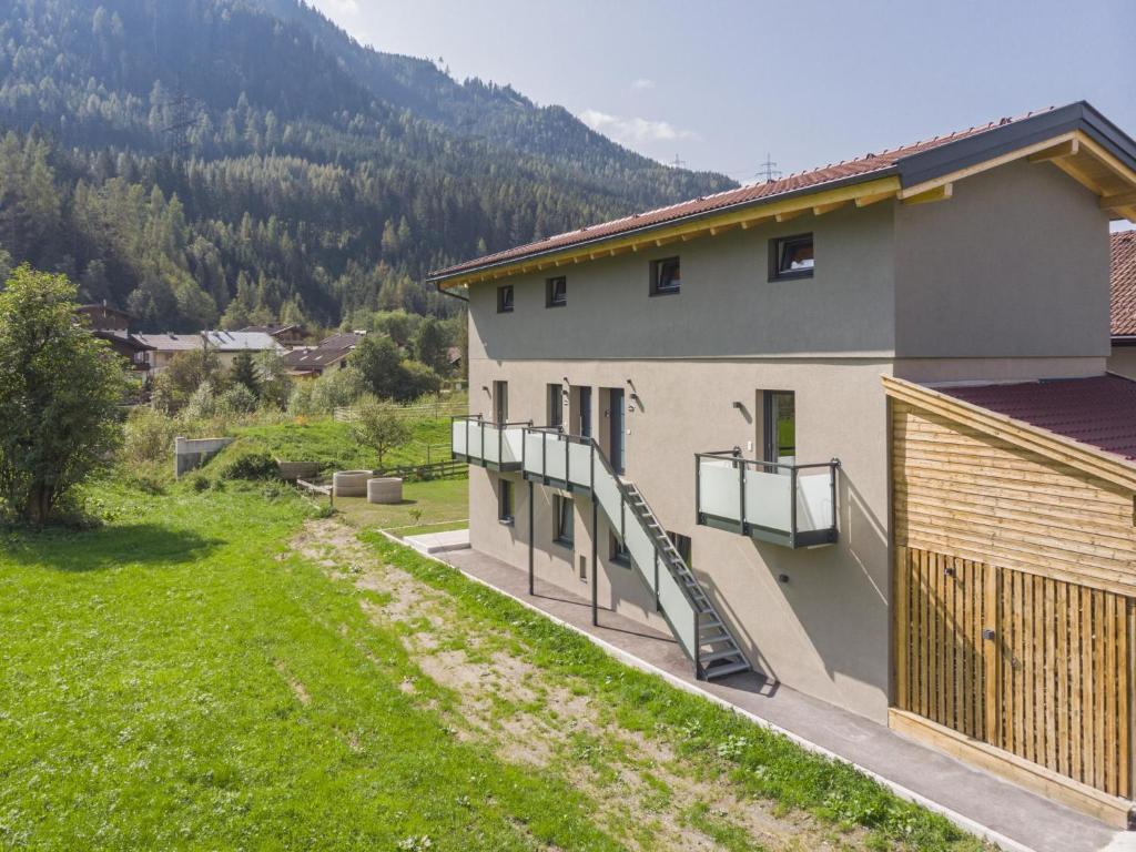 a house with a balcony and a grass yard at Michaela in Bramberg am Wildkogel