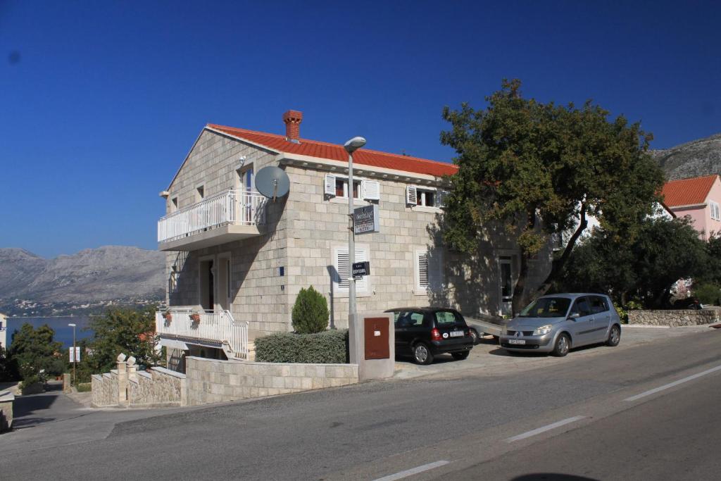 a building with cars parked on the side of a street at Studio Cavtat 8576b in Cavtat