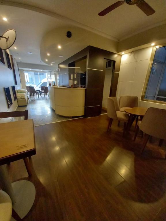 ein Wohnzimmer mit Tischen und Stühlen sowie eine Küche in der Unterkunft Hotel Albamar in Mar del Plata