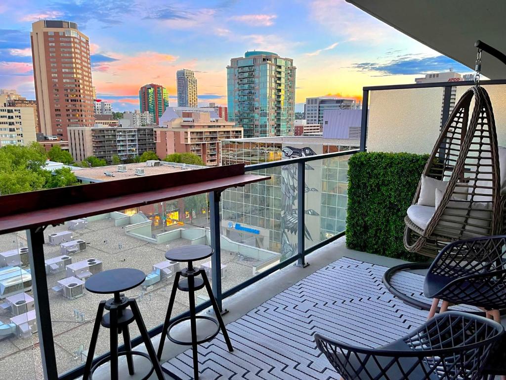 a balcony with stools and a view of a city at LUXURY DT, 2 Bedroom DEAL, Private Balcony, Full Kitchen, Gym - FREE PARKING in Calgary