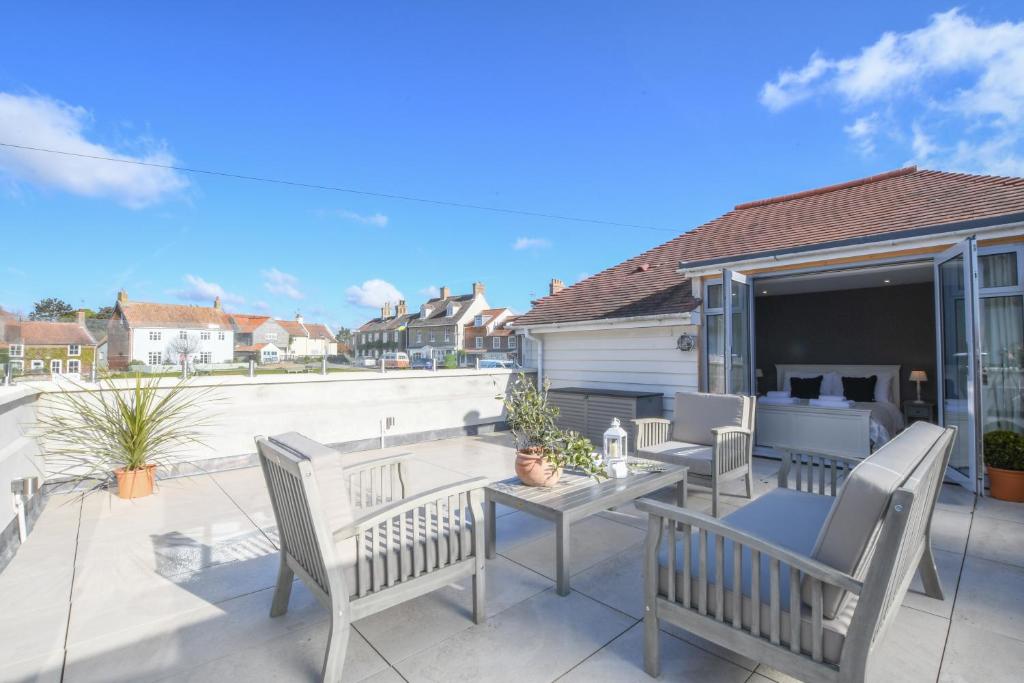 Sea Green Cottage, Walberswick في والبيرسويك: فناء مع كراسي وطاولة على شرفة