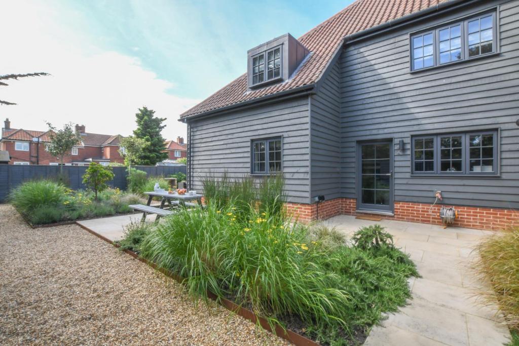 a garden in front of a house with a bench at Corner Cottage, Thorpeness in Thorpeness