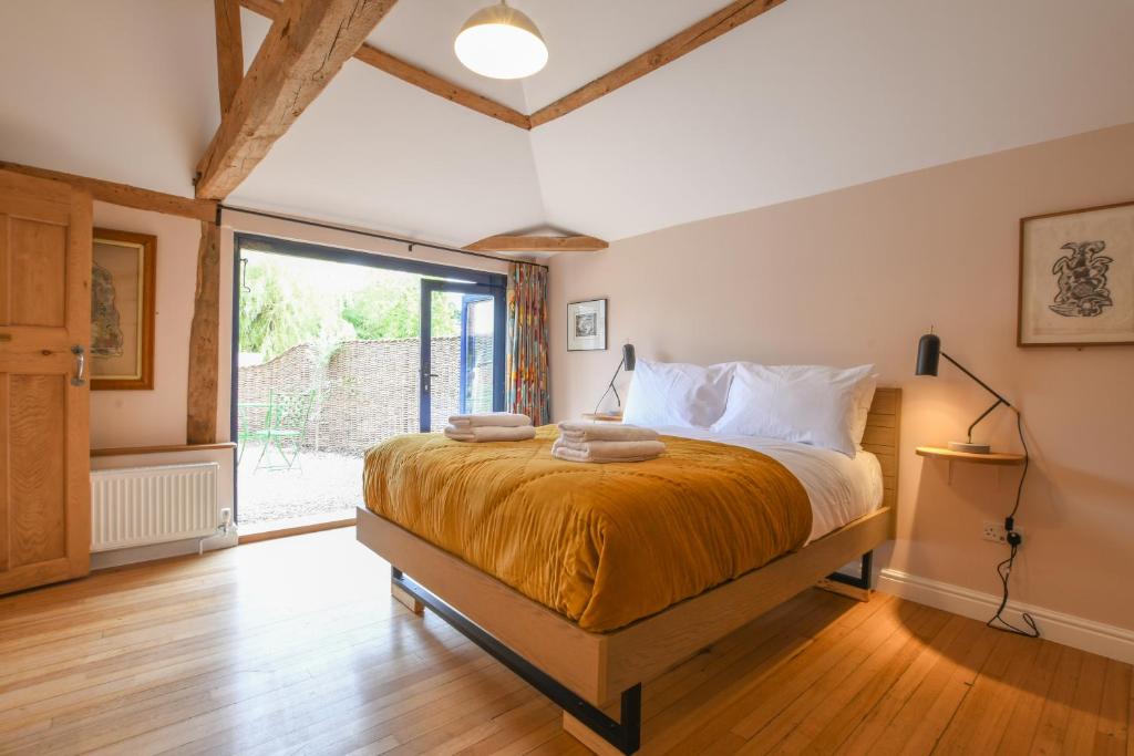 um quarto com uma cama e uma grande janela em Onna's Stable, Sotherton em Sotherton