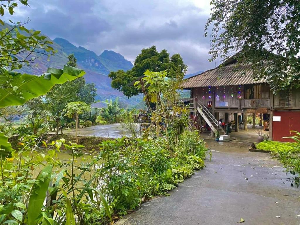 a building with a view of a river and a mountain at Du Già Vân Chung Homestay in Làng Cac