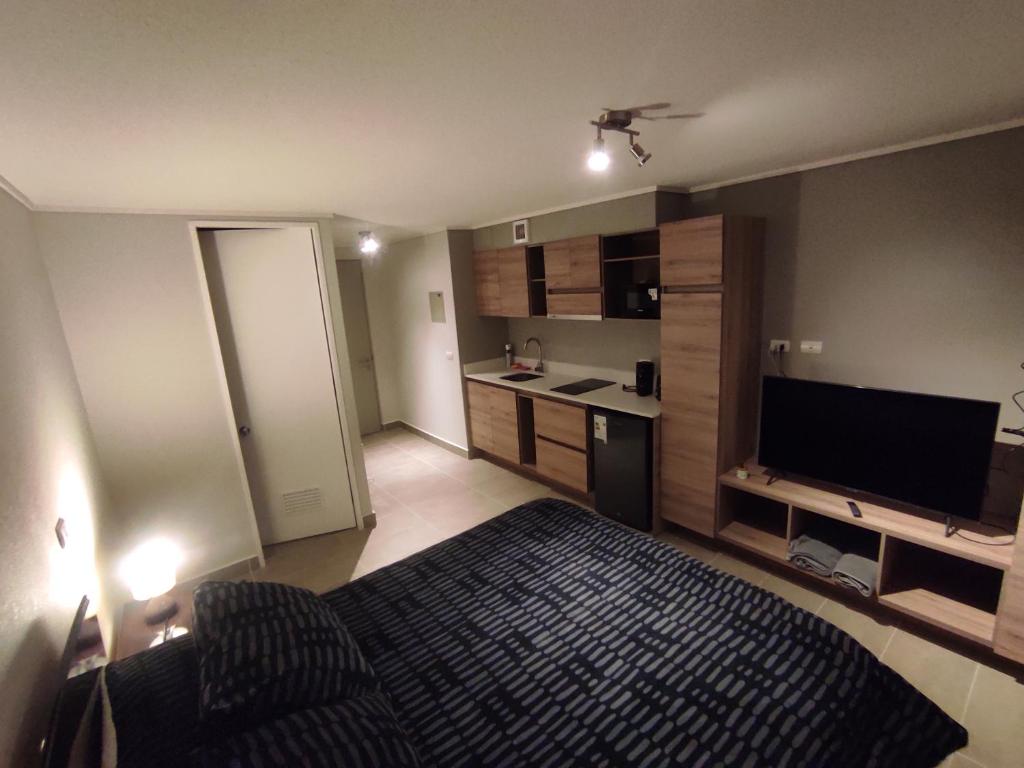 um pequeno quarto com uma cama e uma cozinha em Departamento Estudio en pleno centro de Temuco em Temuco