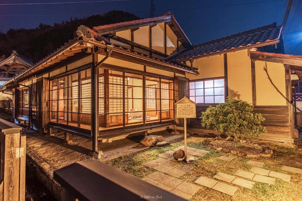 une maison avec un panneau devant elle dans l'établissement Japan's oldest remaining company housing, à Ikuno