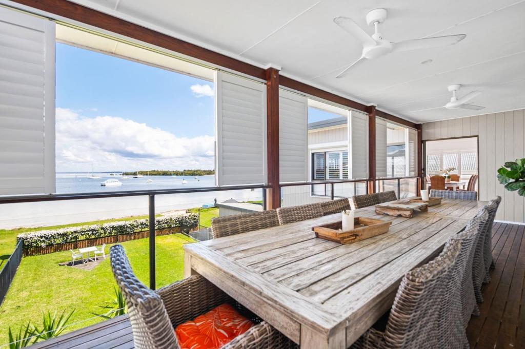 a dining room with a wooden table and chairs at Waterfront at Sunset Boulevard 26 Sunset Boulevard in Soldiers Point