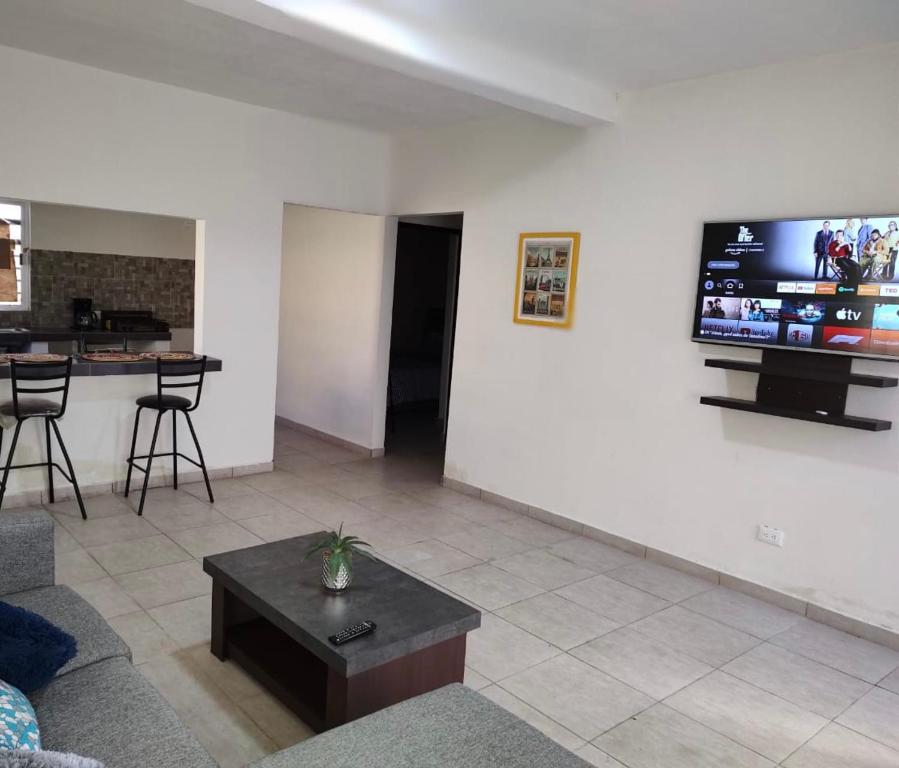 sala de estar con sofá y TV en la pared en Casa equipada Cd Valles, en Ciudad Valles
