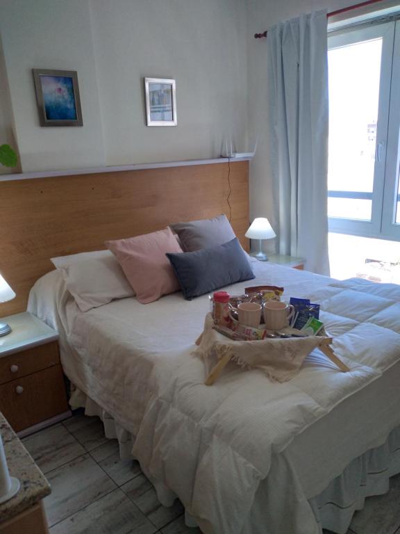 Un dormitorio con una cama con una bandeja de comida. en Arcángeles en Rosario