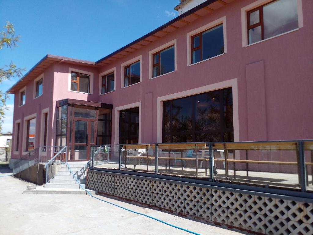a pink building with a ramp in front of it at Kharkhorin hostel in Harhorin