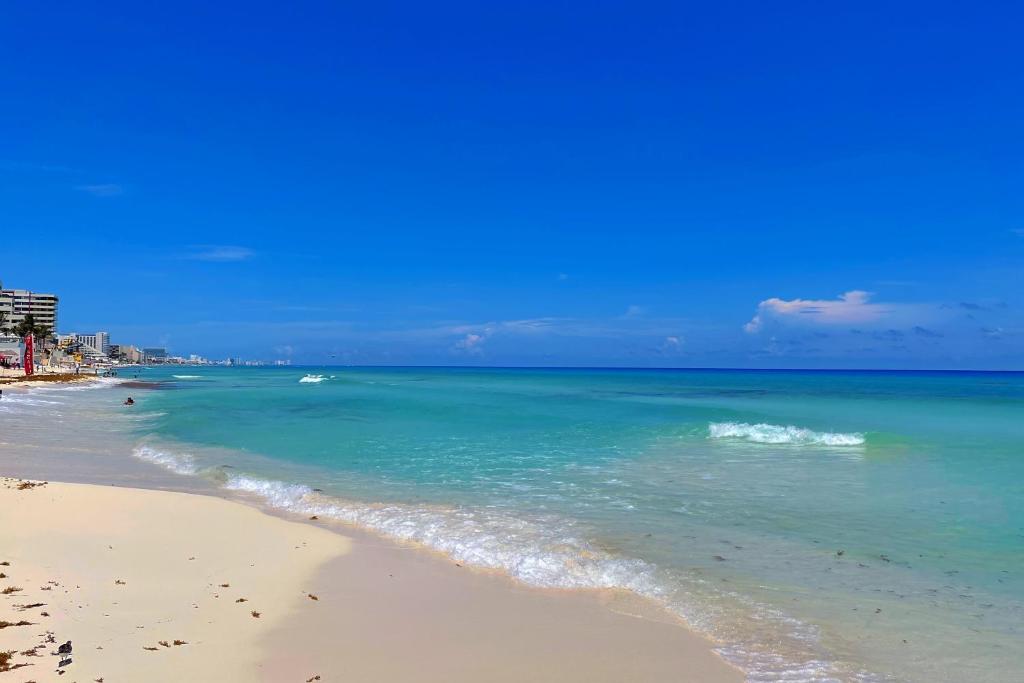 a beach with the ocean on a sunny day at Beach, fun & relax at the Hotel Zone in Cancun in Cancún