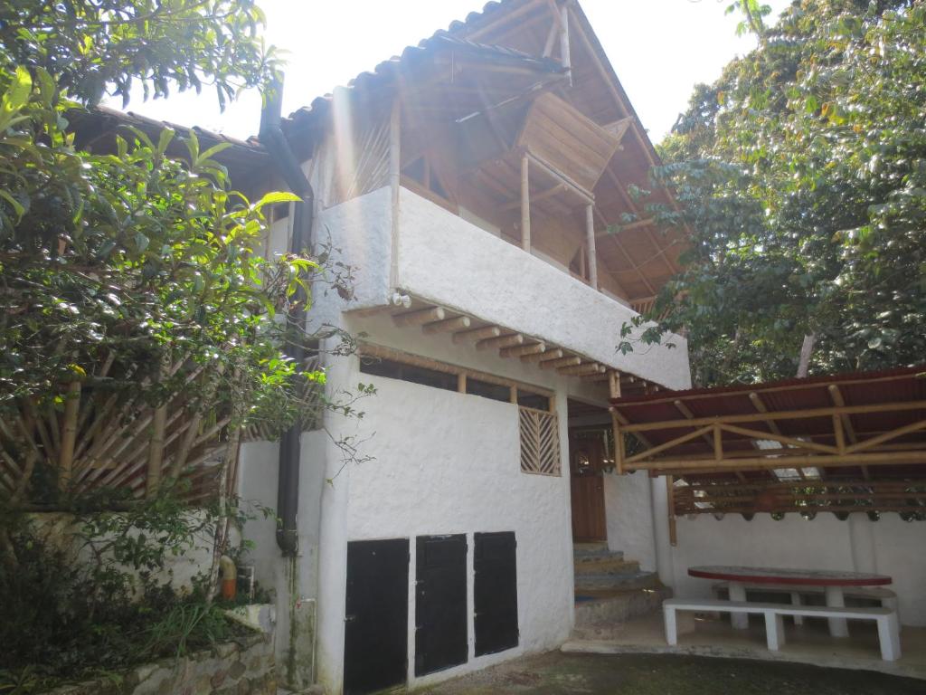 a house with a bench in front of it at Hotel Ecológico La Antigua in San Agustín