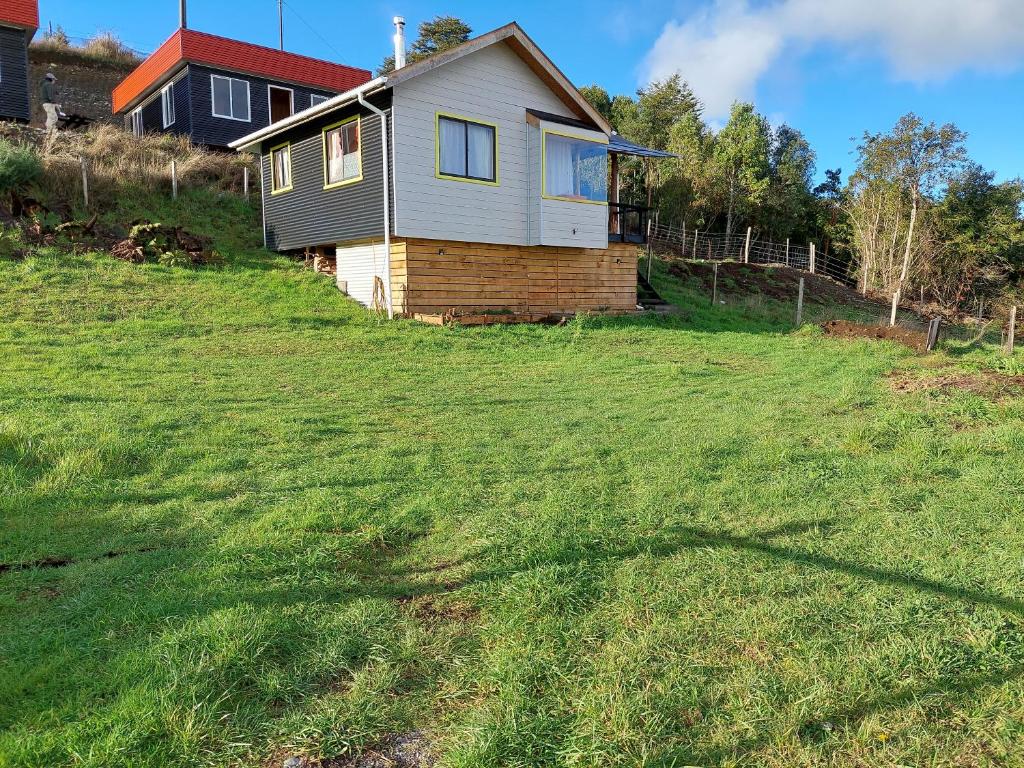 a house sitting on top of a grassy hill at Cabaña dalcahue in Dalcahue