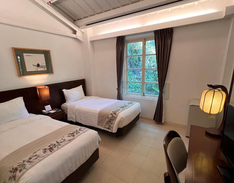 a hotel room with two beds and a window at 饒宗頤文化館 - 翠雅山房 in Hong Kong