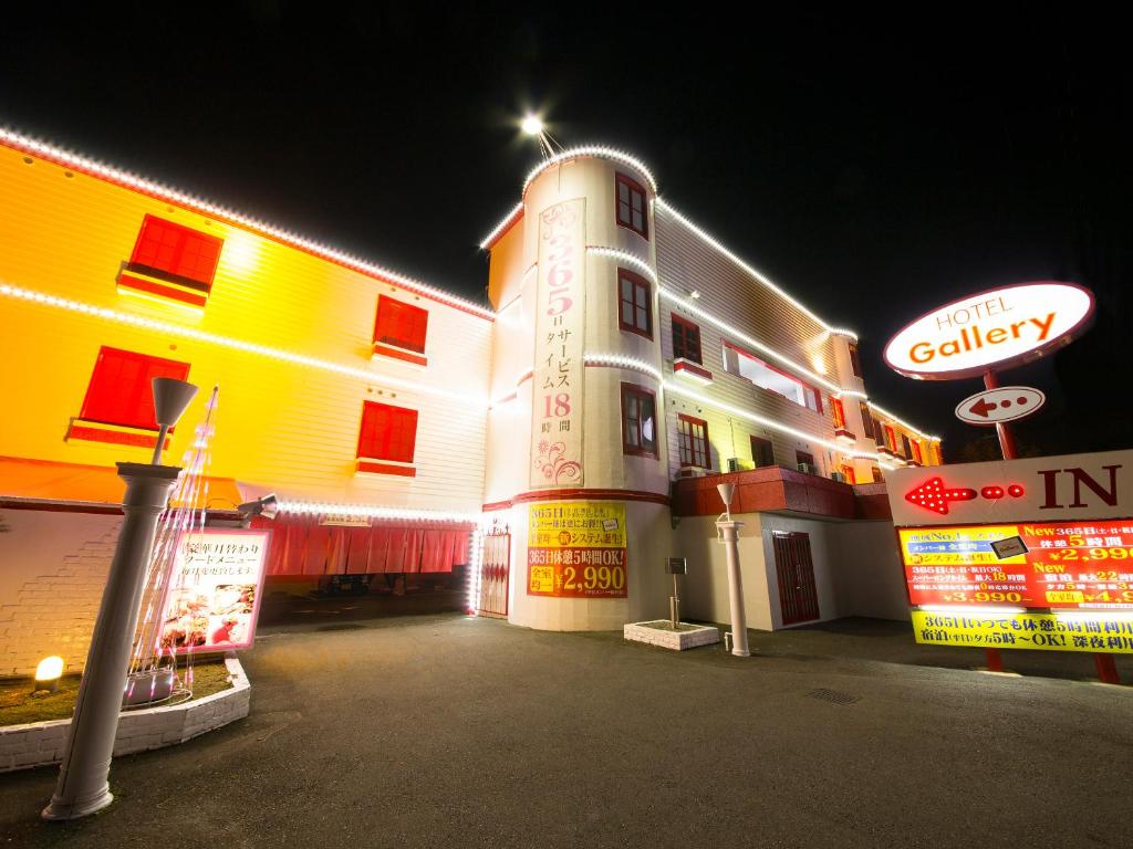 a building with a sign in front of it at night at Hotel Gallery (Adult Only) in Kobe