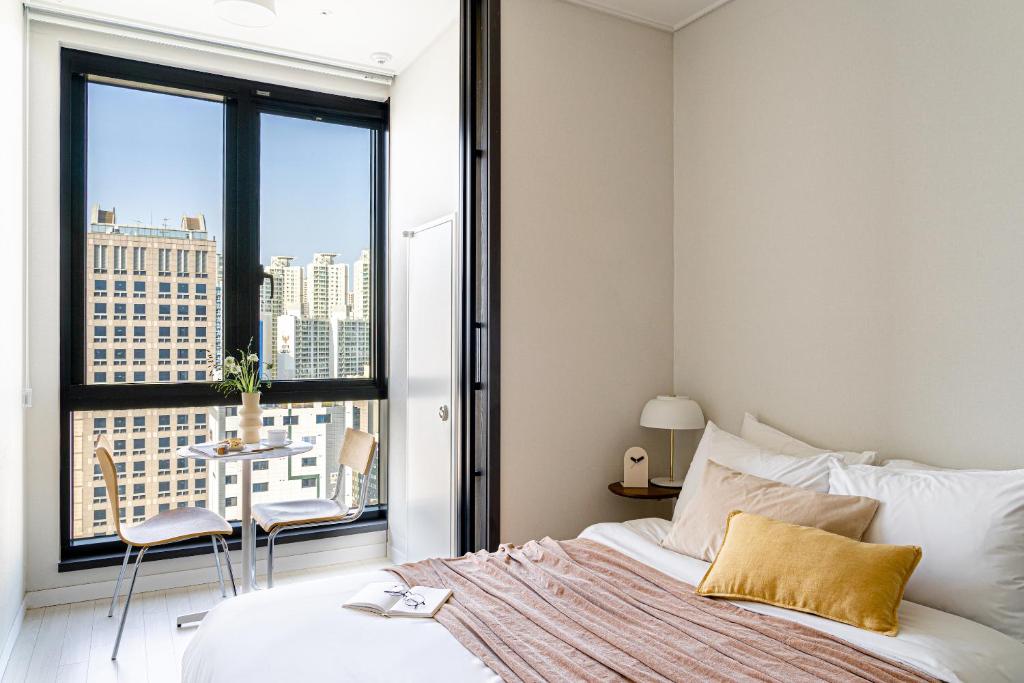 sypialnia z łóżkiem i widokiem na miasto w obiekcie Urbanstay Seomyeon w Pusanie