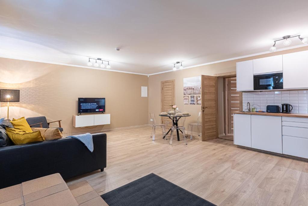 a living room with a couch and a kitchen at Dandelion Apartments Baznīcas in Rīga