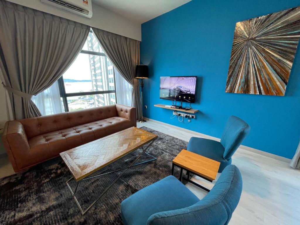 a living room with a brown couch and blue walls at SEAVIEW LUXURY CONDO HOMESTAY 2Bed 2bath Jesselton Quay by R2 Residence in Kota Kinabalu
