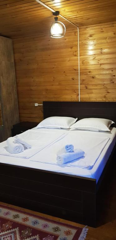 a bed in a room with two towels on it at Wooden Cottages - Mtskheta in Mtskheta