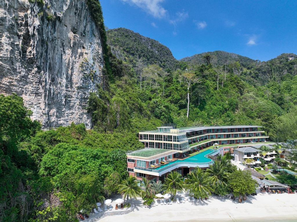 ein Hotel am Strand neben einem Berg in der Unterkunft Phi Phi Cliff Beach Resort-SHA Plus in Ko Phi Phi