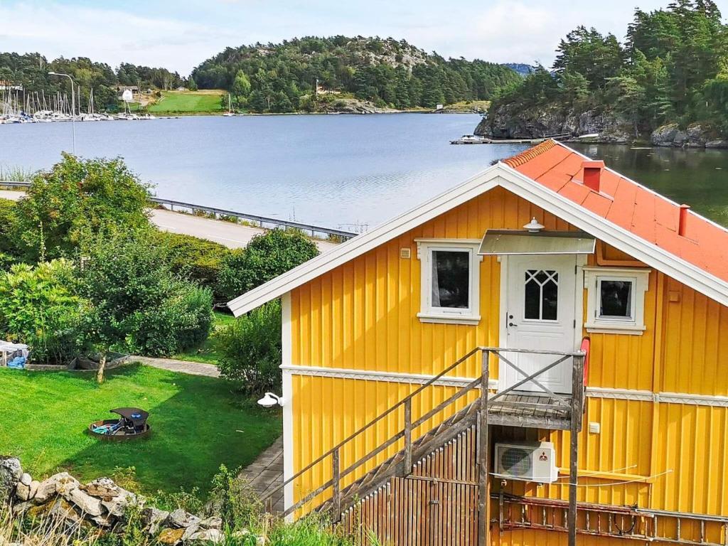 uma casa amarela ao lado de um corpo de água em 4 person holiday home in ELL S em Ellos
