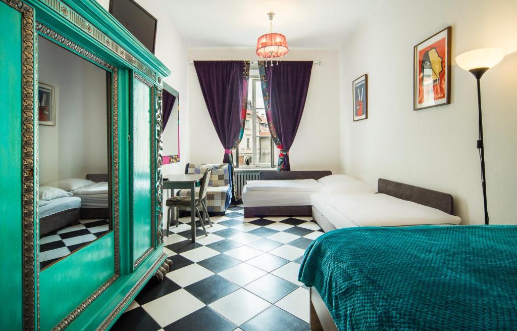 a room with a bed, a chair and a table at Old Town Kanonia Hostel & Apartments in Warsaw