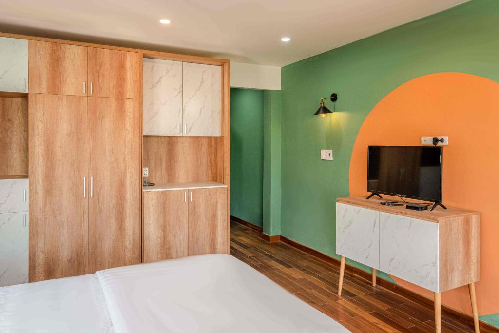 een slaapkamer met een bed en een flatscreen-tv bij POTA Hotel & Apartment in Da Nang