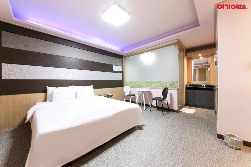 a hotel room with a bed and a table and chairs at Sharp Hotel Jeonju in Jeonju
