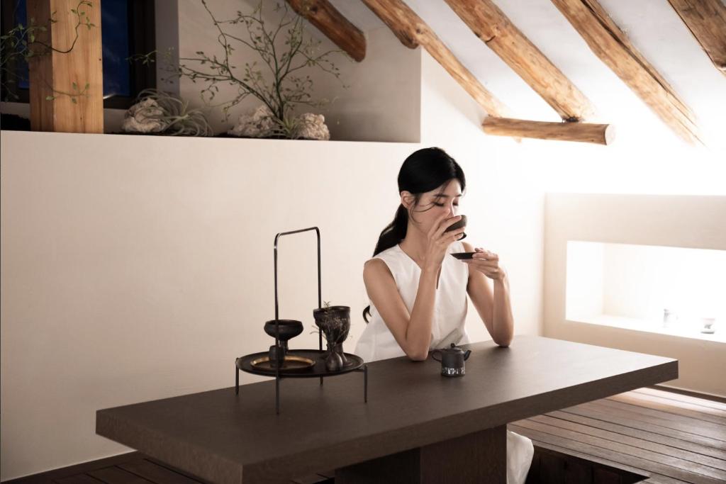 a woman sitting at a table in a room at Haru YeonGa in Gyeongju