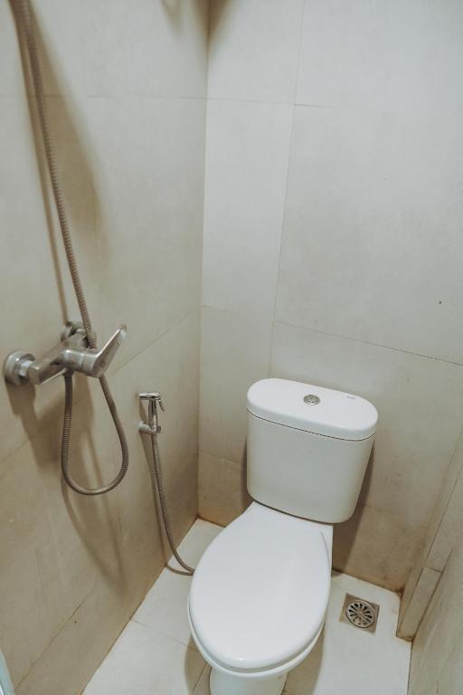 a bathroom with a white toilet and a shower at DS Colive Layur Kota Lama in Semarang