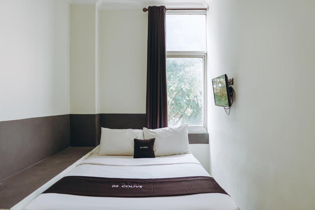 a small bed in a room with a window at DS Colive Layur Kota Lama in Semarang