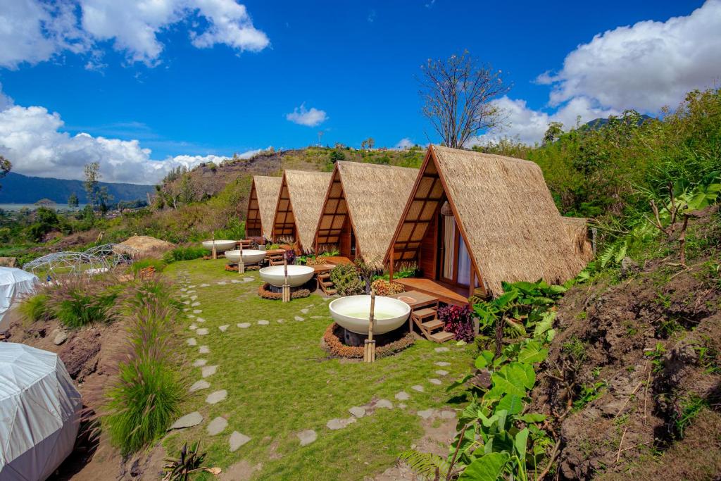 een groep hutten bovenop een heuvel bij Segara Camp Kintamani in Kintamani