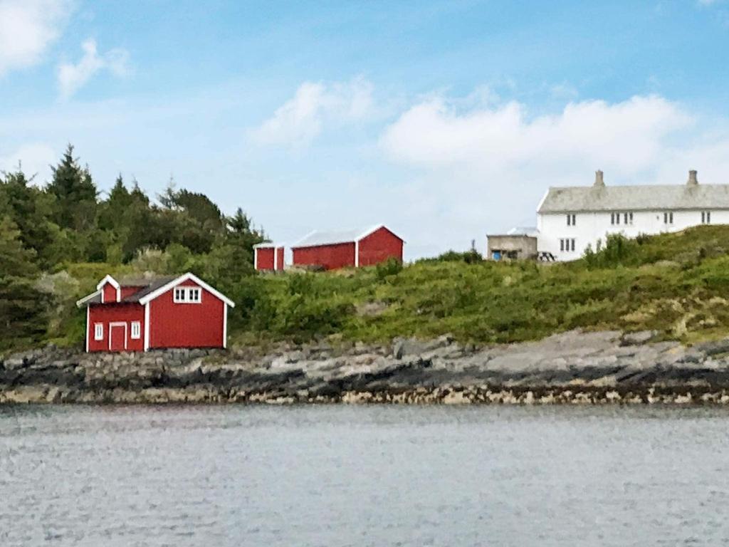 two red and white buildings on a hill next to a body of water at Six-Bedroom Holiday home in Bud in Bud