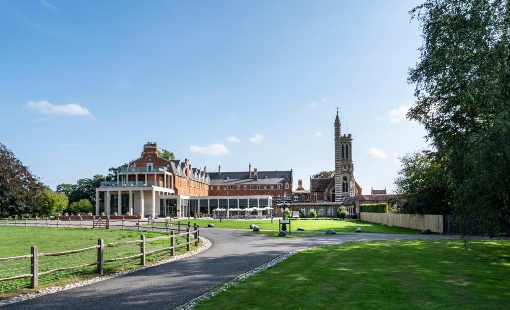 a large building with a fence next to a road at Stanbrook Abbey Hotel, Worcester in Worcester