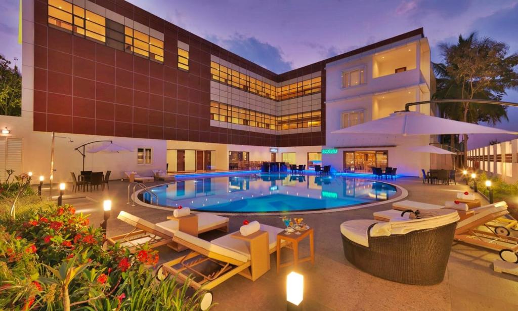 un hotel con piscina y un edificio en Goldfinch Retreat Bangalore, en Devanhalli
