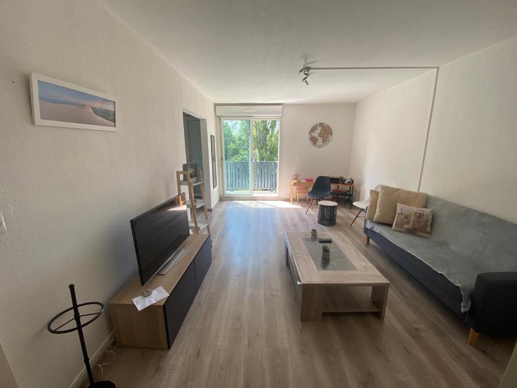 un salon avec un canapé et une table dans l'établissement Appartement 3p, 72m2, centre ville, parking privé tout confort, à Biscarrosse