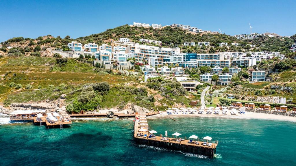 un muelle en el agua junto a un complejo en Sirene Luxury Hotel Bodrum en Yalıkavak