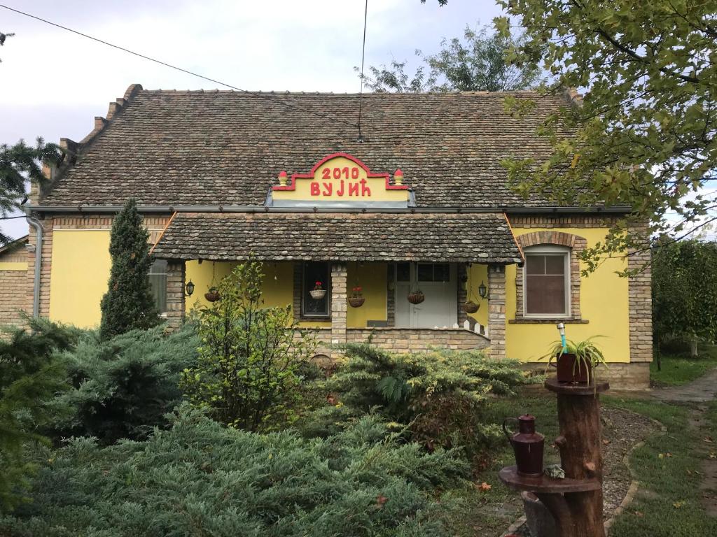 een geel huis met een bord dat luidt end inn bij Salaš Vujić in Bečej