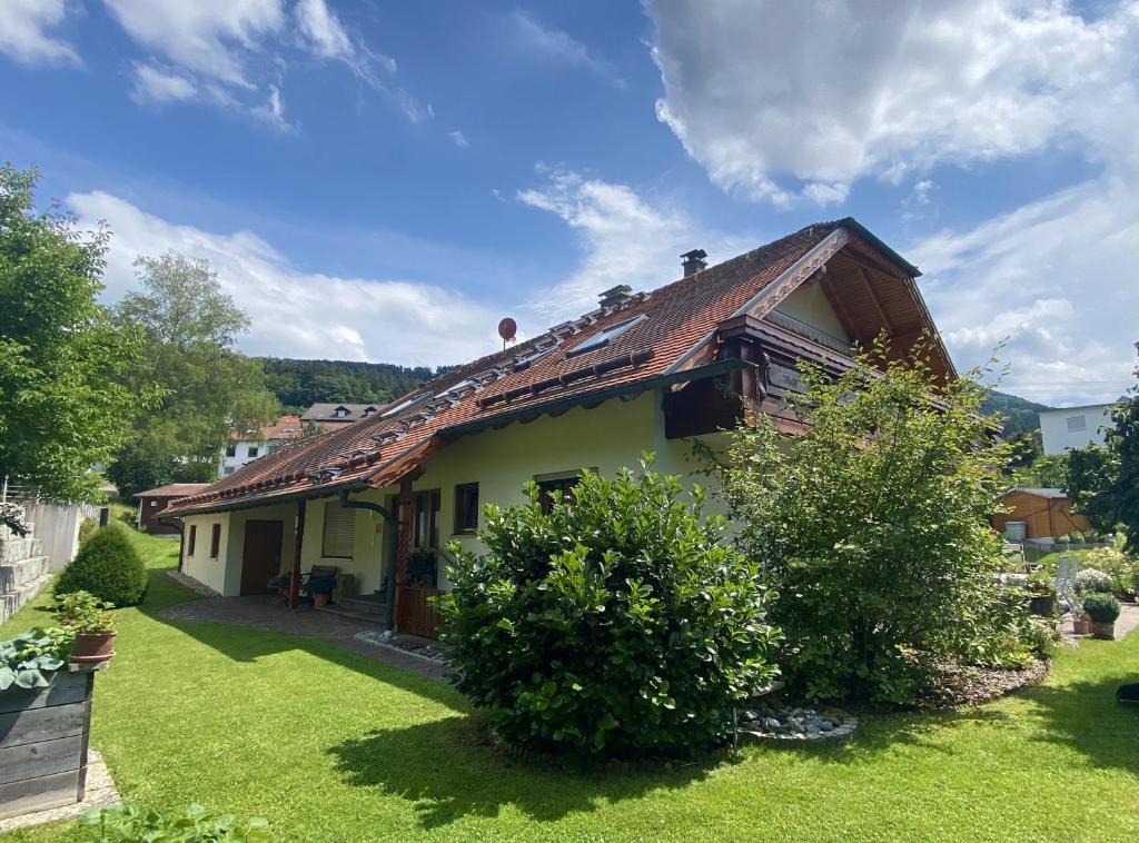 a small yellow house with a green yard at Ferienwohnung Böllatblick in Balingen